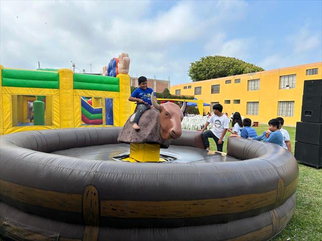 Niño montando el toro mecánico sobre su base inflable