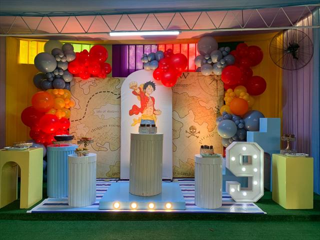 Escenario de cumpleaños decorado con globos y una mesa para la torta