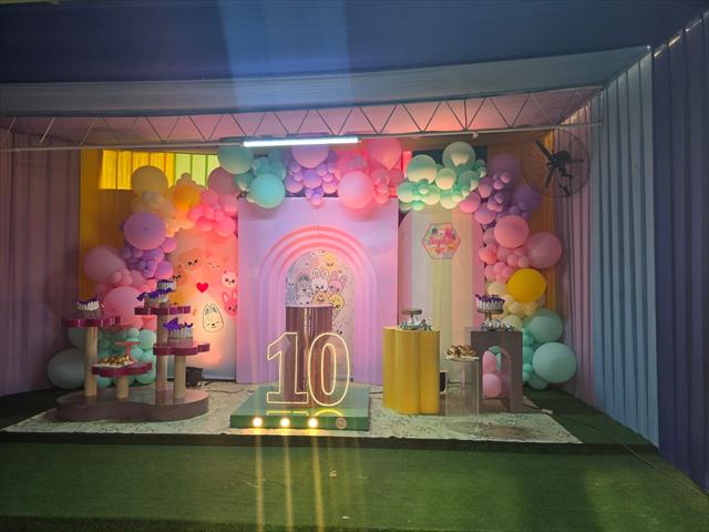 Escenario de cumpleaños en tonos pastel con el número 10