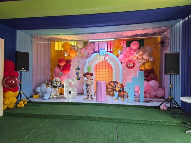 Escenario de cumpleaños decorado en rosa y celeste con globos